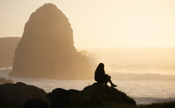 Frau vor der Brandung im Sonnenuntergang